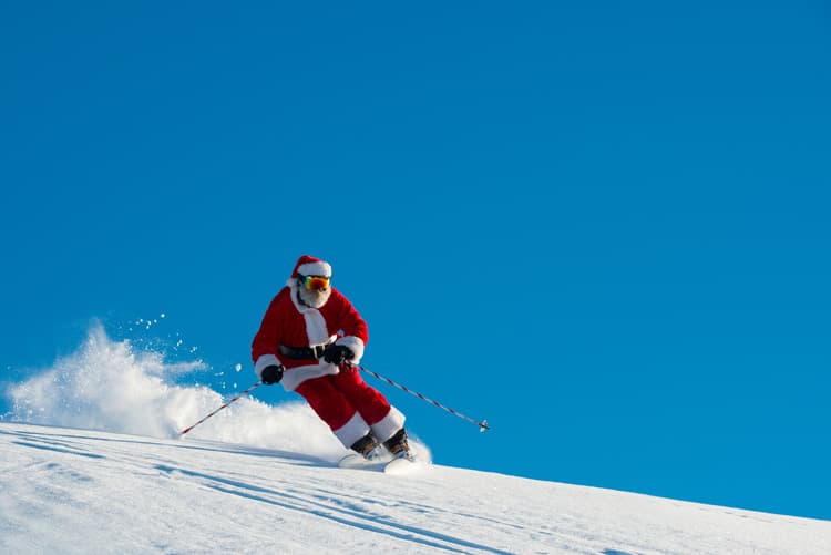 Santa skiing down slope at christmas